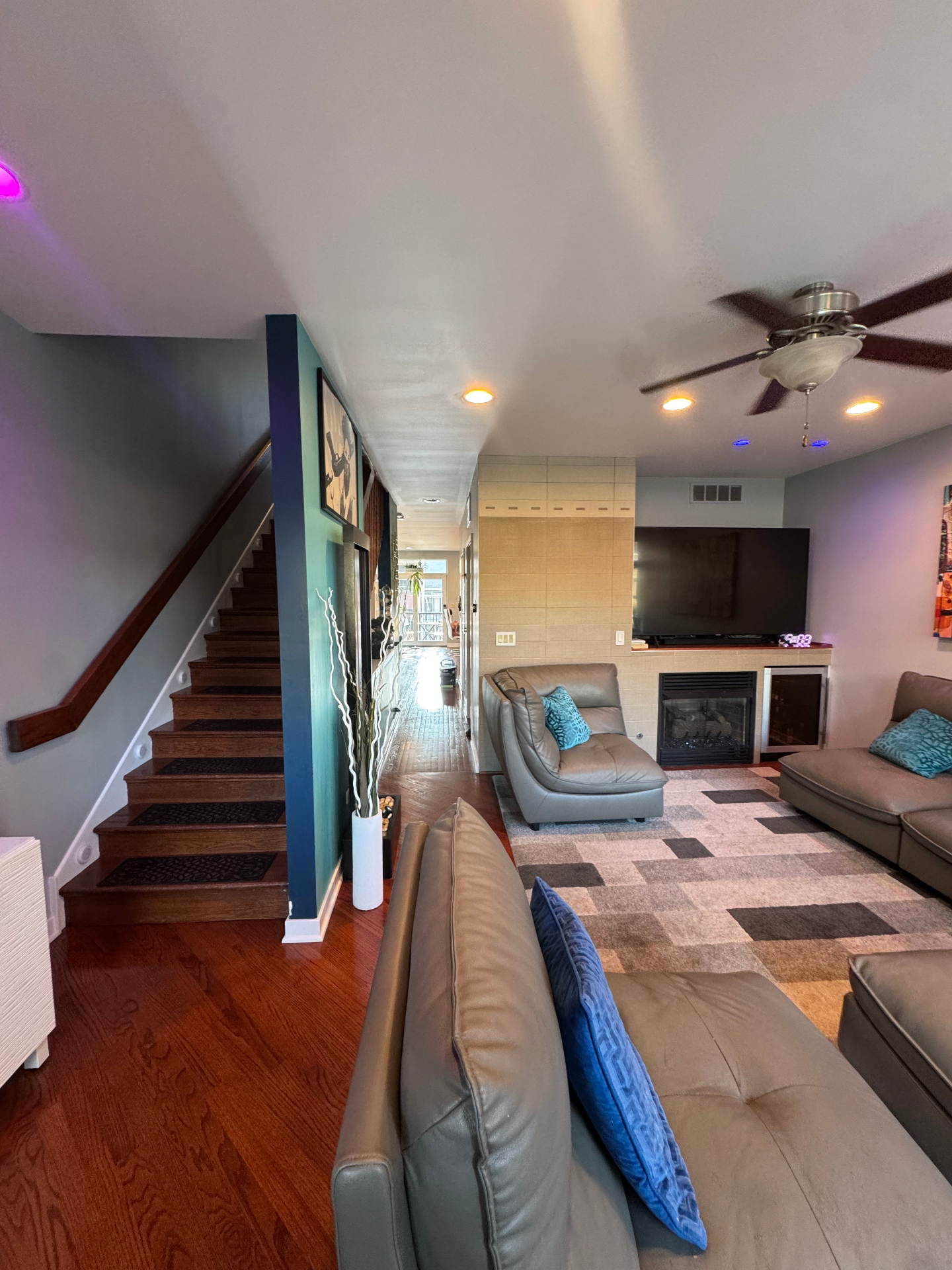 Great room with hardwood floors, fireplace, and staircase