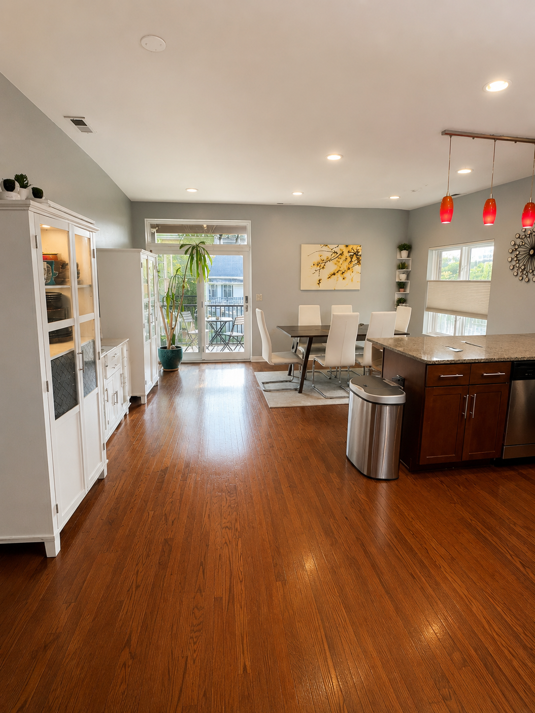 Open kitchen and dining area with hardwood floors and patio access
