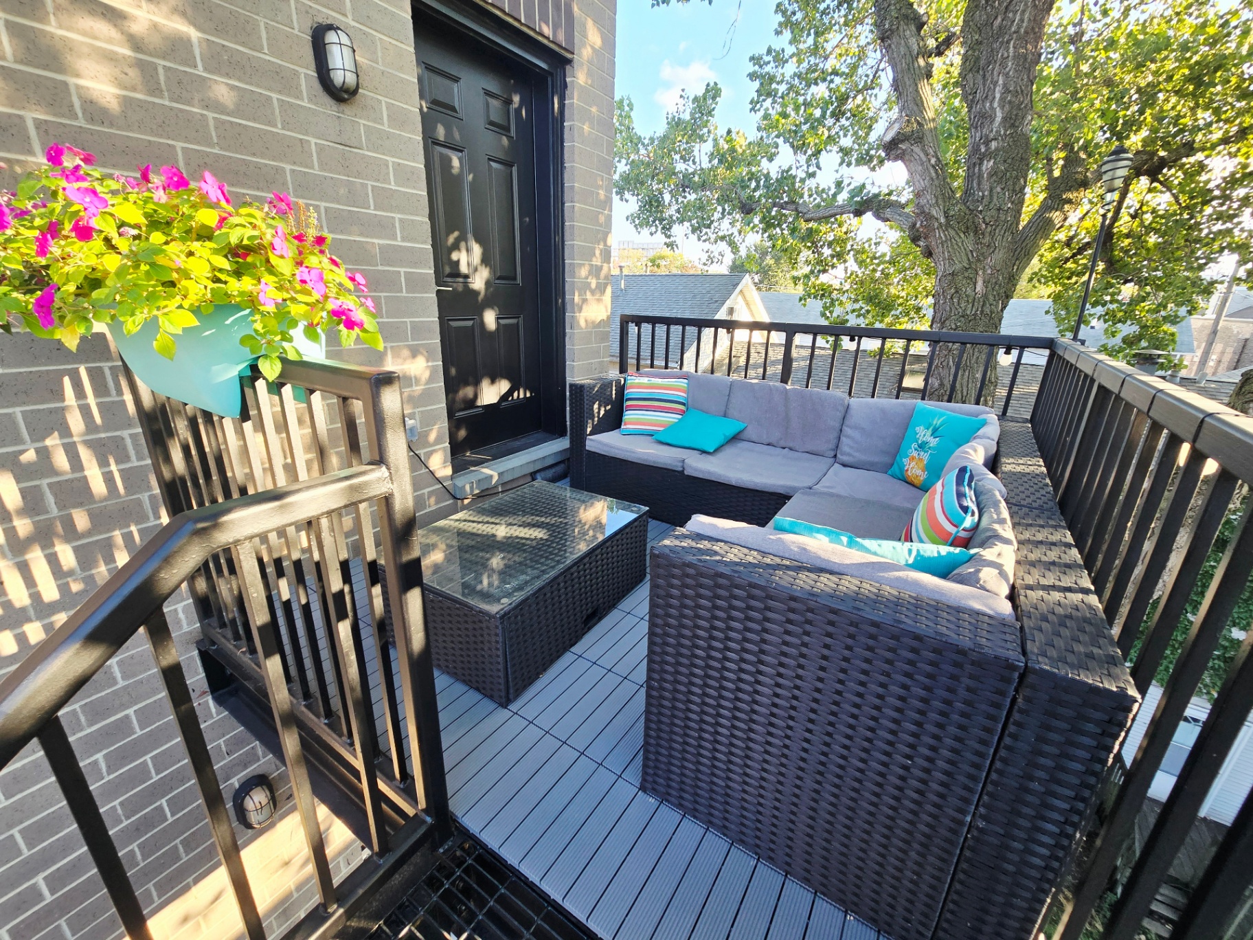 Patio sectional beside the door with flowering planter