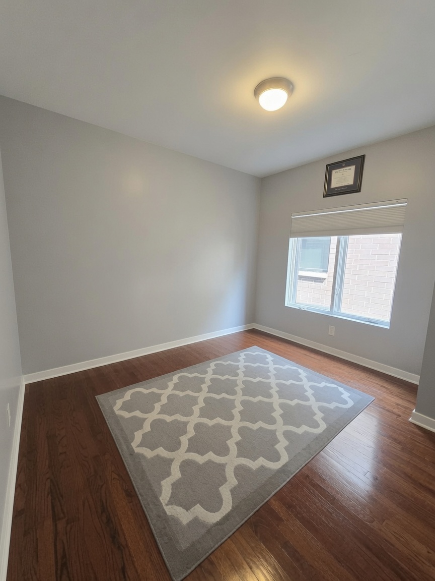 Third bedroom with window and hardwood floors