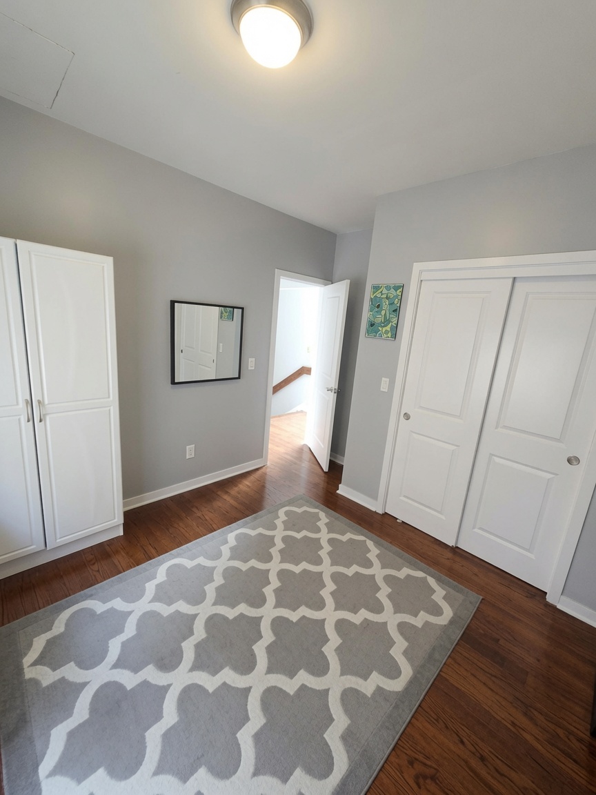 Third bedroom with double closet, wardrobe, and hardwood floors
