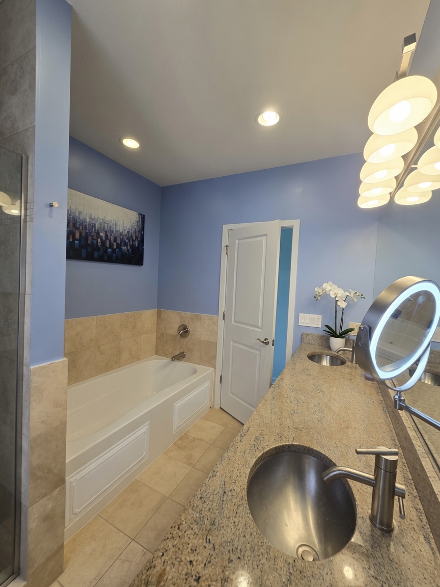 Primary bath with jacuzzi tub and granite double vanity