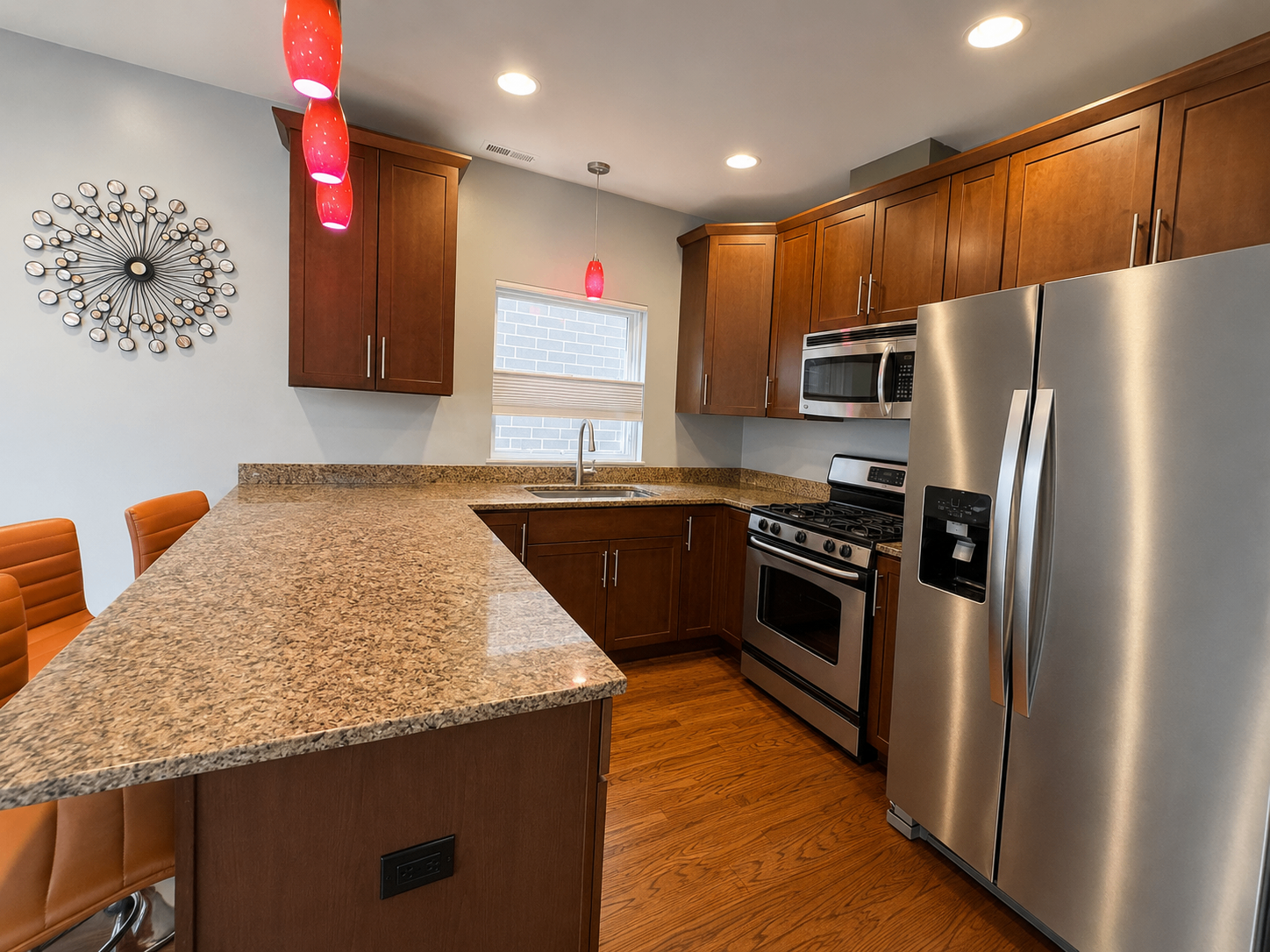 Kitchen with granite peninsula, stainless appliances, and pendant lighting